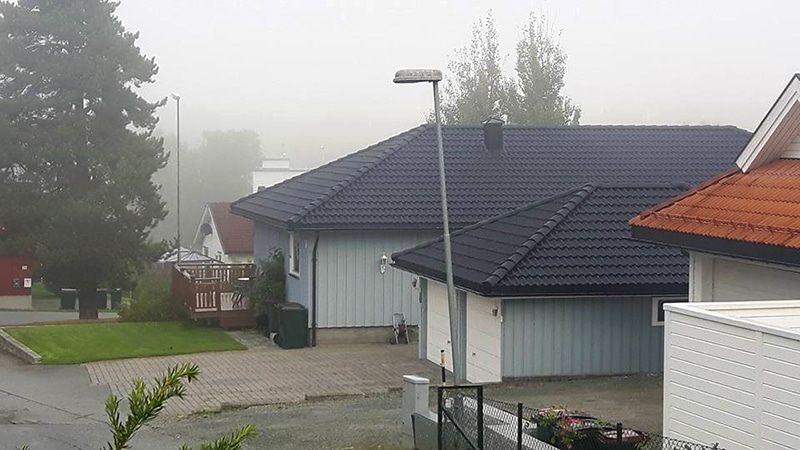Et hus og garasje med sort tak